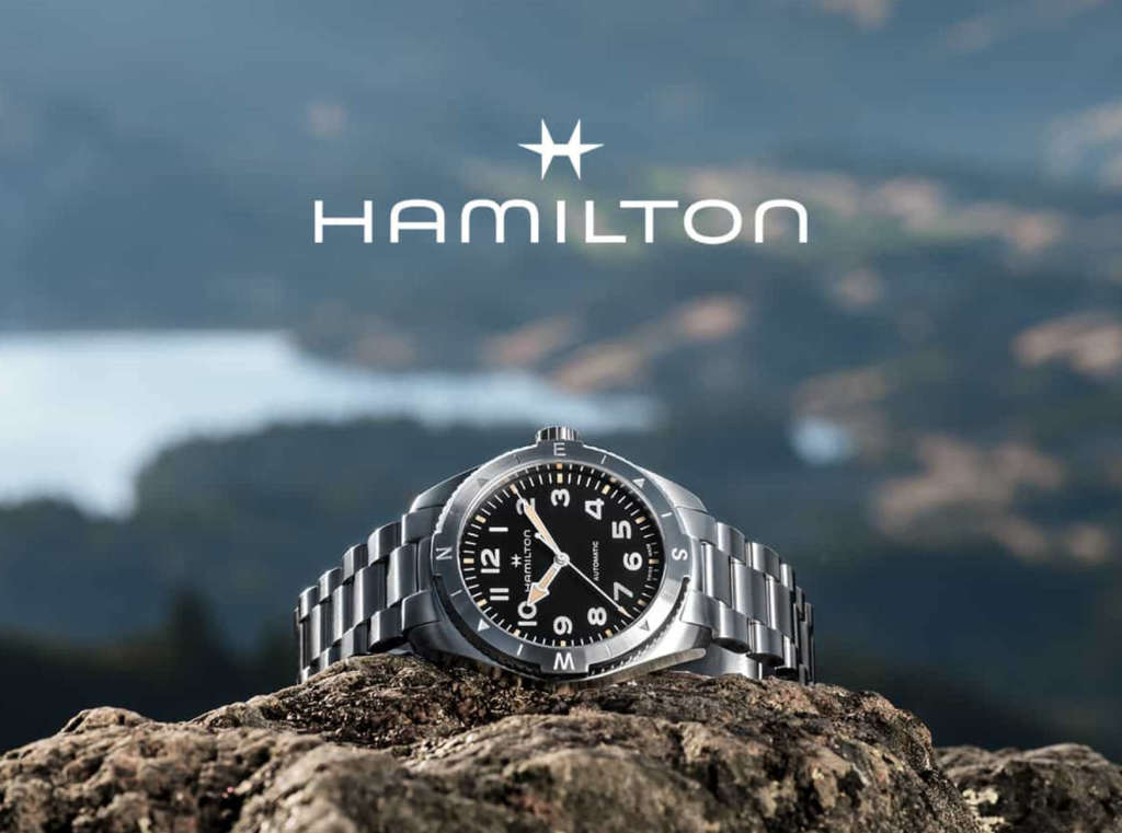 Montre Hamilton posée sur une pierre, montagnes en arrière-plan.