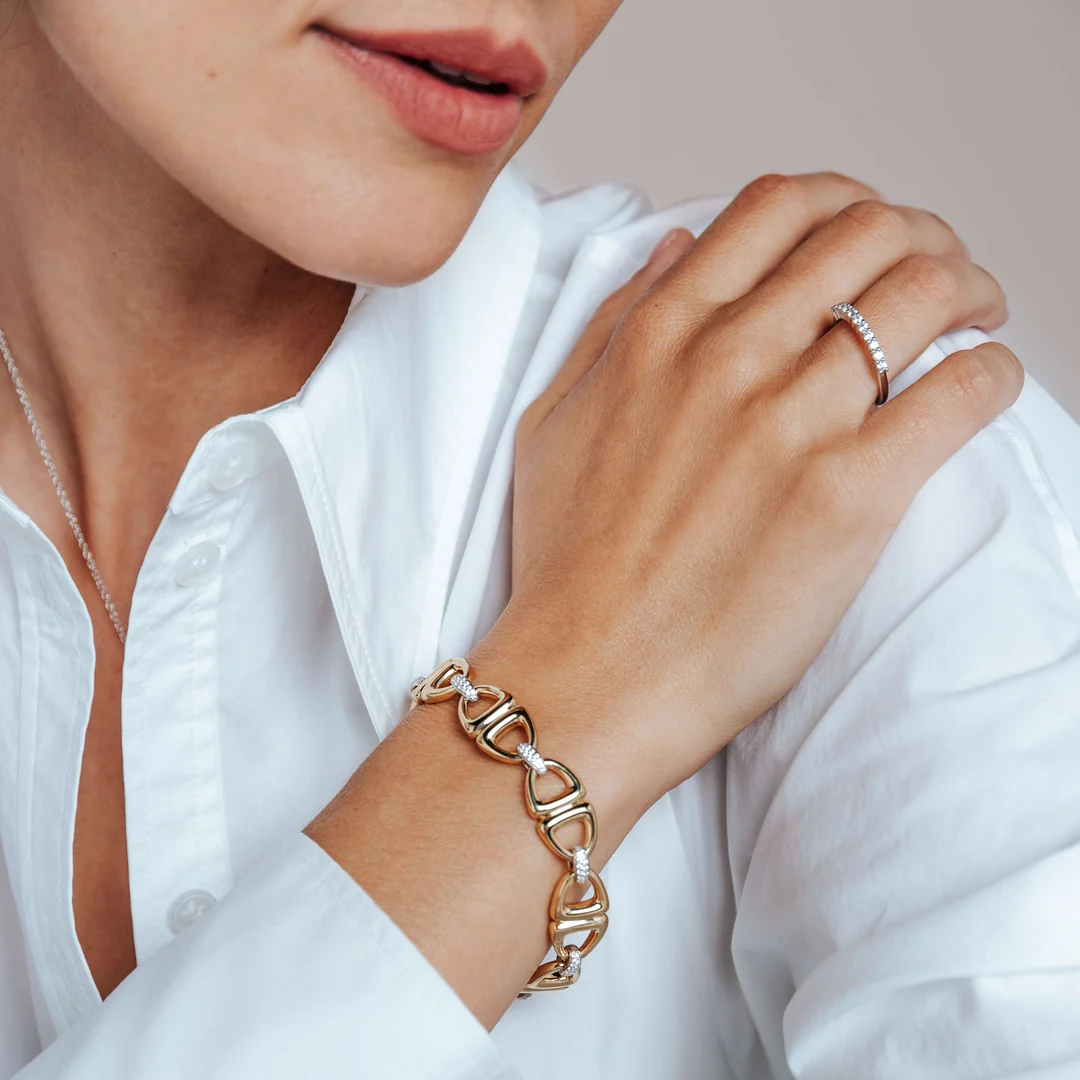 Frau trägt goldenes Armband und besetzten Ring