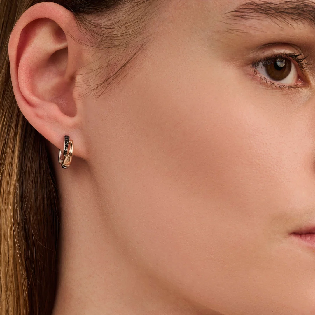 Gros plan d’une boucle d’oreille créole dorée