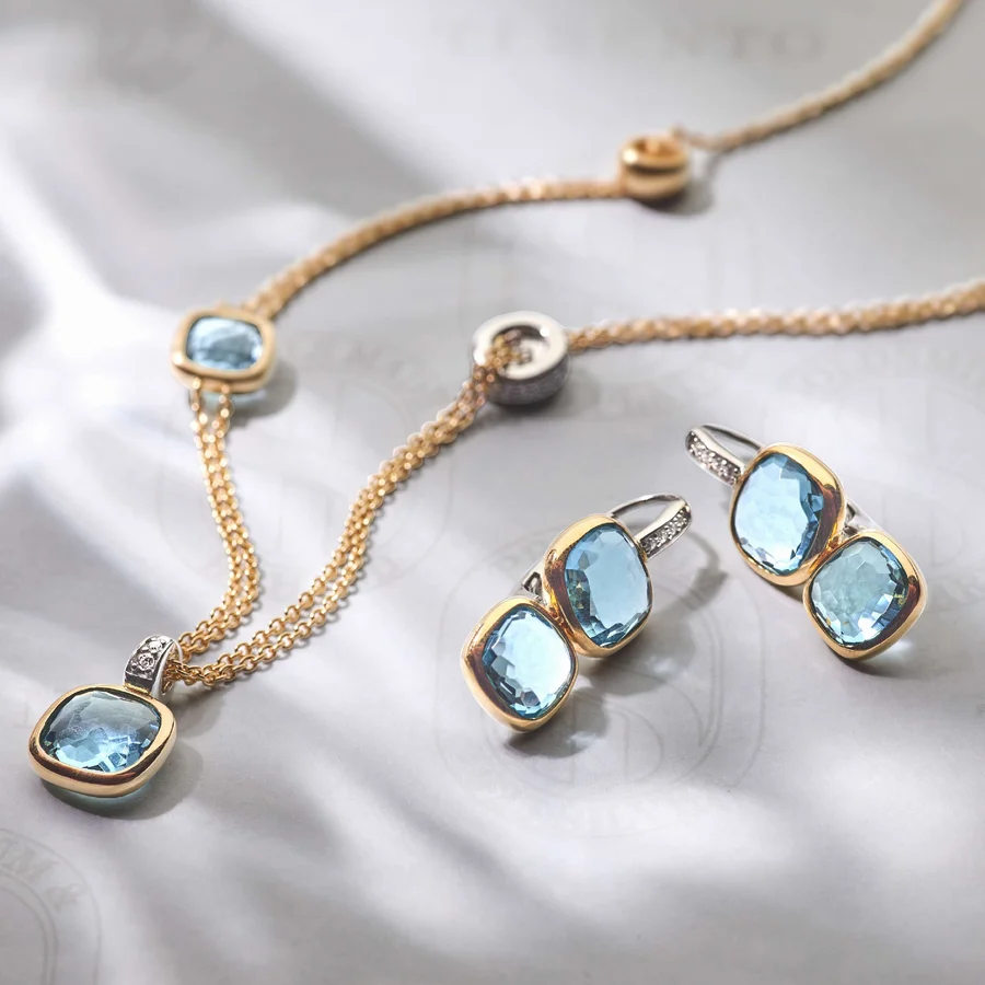 Parure en or et topazes bleues sur fond blanc