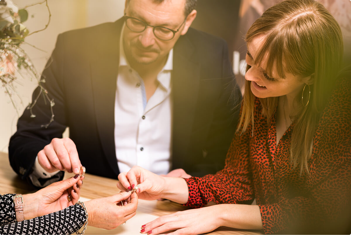 rdv alliances le diamant Couple choisissant des alliances avec une conseillère dans la boutique du Diamant à la Chaux-de-Fonds