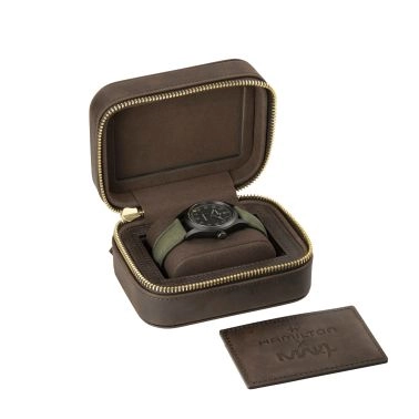 Montre noire dans un étui de voyage marron ouvert